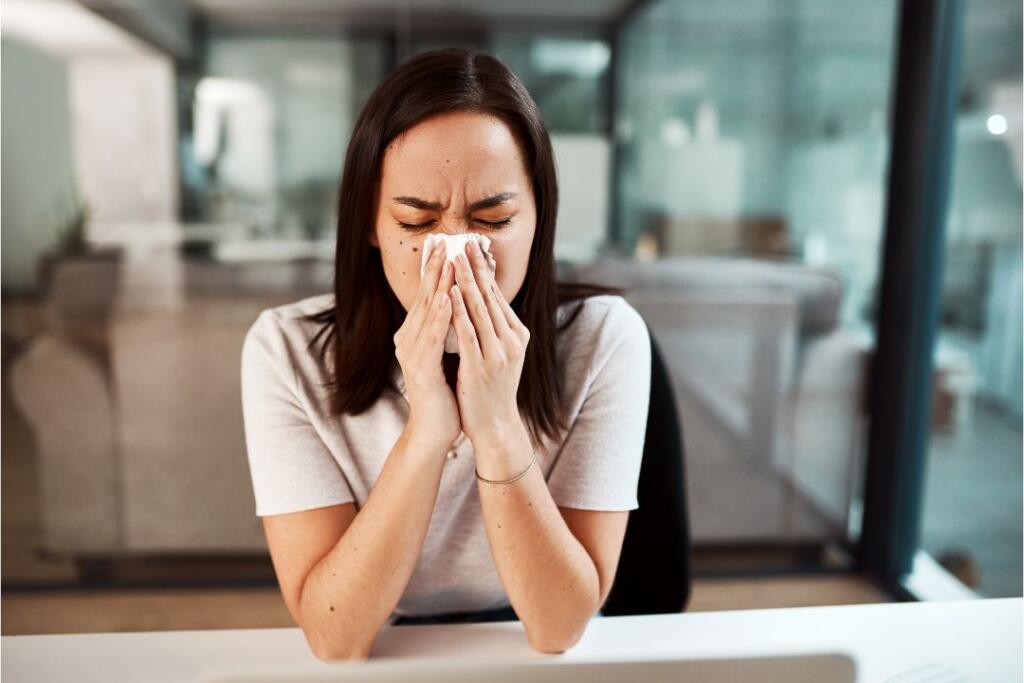 Kobieta wydmuchuje nos z kataru